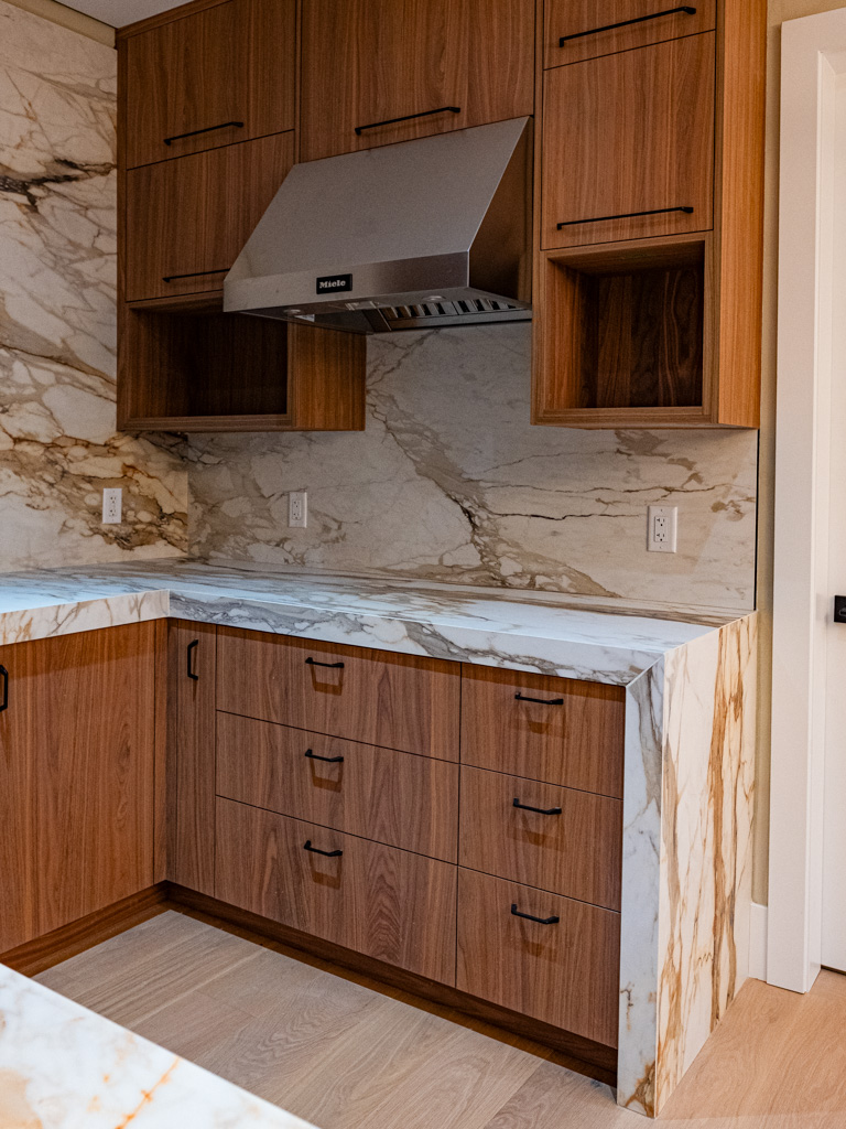 Kitchen with wood cabinets and marble countertops and backsplash