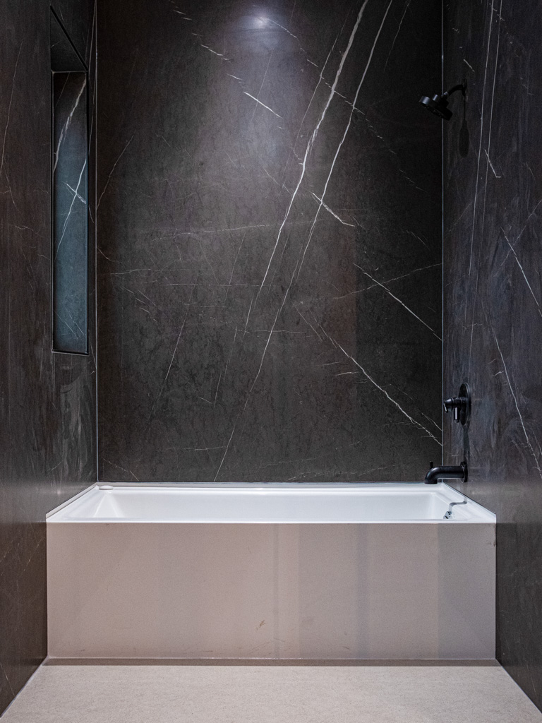 Bathtub in dark veined marble enclosure